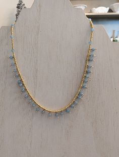 This dainty necklace is made with blue quartz beads and tiny gold seed beads. It is approximately 15" in length. Dainty Gold Crystal Necklace With Tiny Beads, Adjustable Light Blue Necklaces With Tiny Beads, Delicate Gold Beaded Crystal Necklaces, Delicate Gold Beaded Crystal Necklace, Adjustable Gold Crystal Necklace With Dangling Beads, Delicate Gold Beaded Necklaces With Gemstones, Blue Beaded Dainty Necklace, Dainty Blue Beaded Necklace With Faceted Beads, Dainty Blue Necklace With Tiny Beads