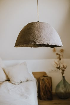 a bedroom with a bed, vases and lamp hanging from it's ceiling