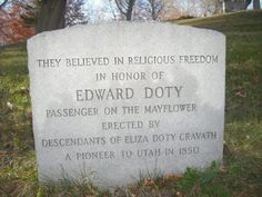 a grave marker for edward doty sits in the grass