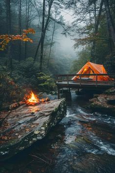 a tent is set up on a bridge over a stream with a fire in the foreground