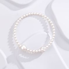 Experience elegance redefined with our "Eternal Embrace" White Freshwater Pearl Bracelet. Two large pearls gracefully frame the open closure, forming a captivating large circle that symbolizes unity and endless beauty. The design's simplicity accentuates the pearls' natural allure, making it a versatile piece suitable for both casual and formal occasions. A classic with a contemporary twist, this bracelet is a timeless addition to any jewelry collection. Pearl size 5-7mm Note: Our jewelry is han Elegant Adjustable Bracelet With Pearl Pendant, Adjustable Pearl Bracelet With Pearl Pendant, Elegant Adjustable Bracelets With Pearl Pendant, Adjustable Pearl Bracelets With Pearl Pendant, Adjustable Bracelet With Pearl Pendant, Formal Pearl Bracelet With Pearl Charm, Pearl White Bangle Bracelet With Pearl Charm, Pearl White Bangle With Pearl Charm, Gold Pearl Bracelet With Pearl Chain