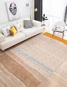 a living room filled with furniture and a large rug on top of a hard wood floor