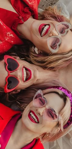 three women with heart shaped sunglasses on their faces