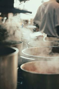 several pots with steam rising from them in a kitchen