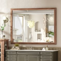 a large mirror hanging on the wall above a sink