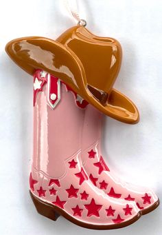 Bring a touch of country flair to your holiday décor with this adorable cowgirl boot ornament! Featuring a light pink boot adorned with bold red stars and topped with a classic brown cowboy hat, this ornament perfectly captures the spirit of the Wild West. Whether you're a rodeo lover, country music fan, or simply enjoy a western theme, this ornament will make a playful and unique addition to your Christmas tree. Perfect for cowgirls at heart or as a gift for someone who loves all things western, this durable and lightweight ornament adds a festive, rustic touch to your holiday celebrations. Personalize it with a name or message to make it extra special! Check out the last photo to choose which font you want for personalization! Pink Western Boots For Rodeo, Metallic Pink Cowboy Boots, Christmas Cowboy Boots, Light Pink Boots, Felt Cowboy Boot Ornament, Pink Western Boots For Ranch, Cowboy Boot Ornaments, Cowboy Boot Keychain, Boot Ornament