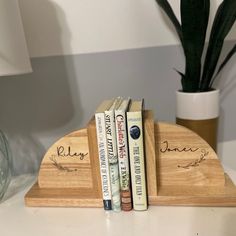 three books are sitting on a wooden book holder