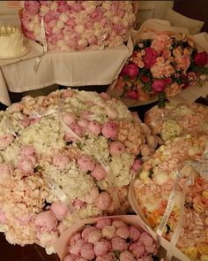 a table topped with lots of different types of flowers and cake on top of it