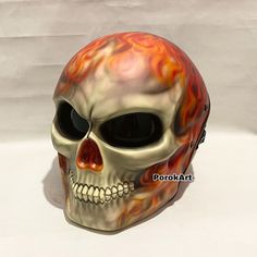 a skull with flames painted on it's face is shown in front of a white background