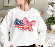 Bow 4th Of July Sweatshirt, USA Sweatshirt, America Sweatshirt, Flag Sweatshirt, Bow Sweatshirt, Independence Day, Gift For Her If you are looking for soft, comfortable, premium sweatshirts and hoodies you are in the right place! A B O U T   O U R   P R O D U C T S *Hoodie -Adult unisex sizing,  -Tear away label,  -Ribbed collar,  -Cuffs and waistband with spandex,  -Pouch pocket, double-blend hoodie with matching drawstring  -Mid-weight 8.0 oz. -50% cotton, 50% polyester -Heather sport colors a White Crew Neck Sweatshirt For 4th Of July, White Long Sleeve Tops For Independence Day, White Long Sleeve T-shirt For Independence Day, White Long Sleeve T-shirt For 4th Of July, Patriotic Long Sleeve Sweatshirt For Independence Day, America Sweatshirt, Bow Sweatshirt, Independence Day Gift, Usa Sweatshirt