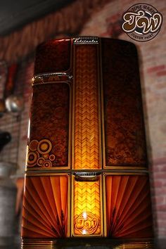 an image of a brown and yellow box with lights on it's sides in front of a brick wall