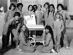 an old black and white photo of young women in uniforms posing for a group photo