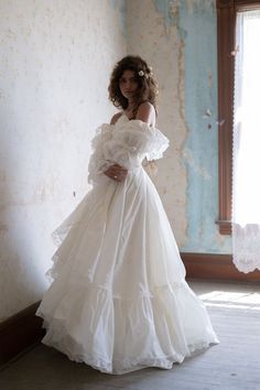 a woman in a white dress posing for the camera