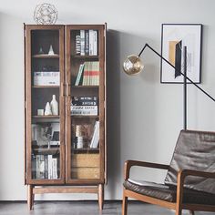 a book case sitting next to a chair in a living room