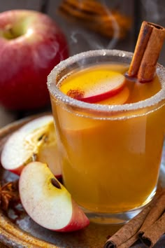 an apple cider is garnished with cinnamon and apples