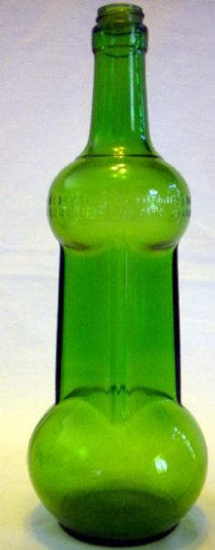 a green glass bottle sitting on top of a table