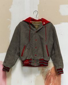 "Wool varsity/letterman jacket from Lorain Catholic High School, circa '70s/'80s. Grey wool body with red snaps, red leather trimmed pockets and red/grey striped ribbed knit cuffs and hem. Split zippered snap-down hood with \"Lorain Catholic\" embroidery and red drawstring. Embroidered patch with name \"MaryJo\" at hem. Embroidered number \"93\" at left sleeve. Flat Measurements: Armpit to Armpit: 23\" Shoulder to Shoulder: 17.5\" Sleeve Length: 23\" Total Length: 24\" Head to our Sizing Guide t Catholic Embroidery, Embroidered Number, Catholic High School, Varsity Letterman Jackets, Letterman Jacket, Camo Colors, Summer Pants, Embroidered Patch, Red And Grey