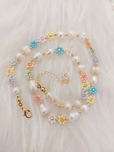 the multicolored beaded necklace is displayed on a white furnishing surface