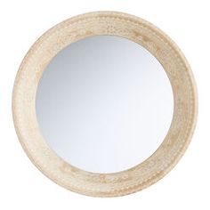 a white round mirror sitting on top of a wall