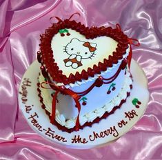 a heart shaped cake with hello kitty on it