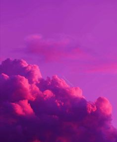 an airplane is flying in the sky with purple and pink clouds behind it at sunset