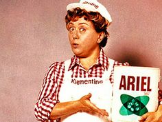 a woman in an apron holding a box of ariel cereal with the word ariel on it