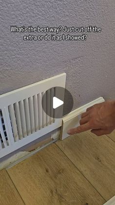 a person is pointing at the radiator on the wall