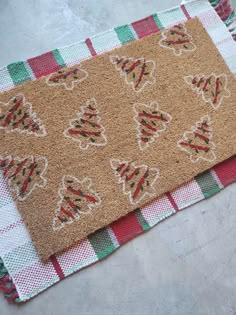 a brown door mat with christmas trees on it