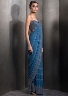 Draped pre-stitched tulle sari embellished with tonal embroidery with matching embroidered blouse. Embroidered Silk Pre-draped Saree For Evening, Fitted Blue Pre-draped Saree With Intricate Embroidery, Evening Embroidered Pre-draped Saree, Unstitched Blue Pre-draped Saree With Intricate Embroidery, Party Blue Pre-draped Saree With Intricate Embroidery, Blue Embellished Evening Dupatta, Embellished Blue Evening Dupatta, Semi-stitched Embellished Blue Blouse Piece, Blue Georgette Evening Choli