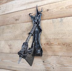 a metal hook on the side of a wooden wall with an animal's head attached to it