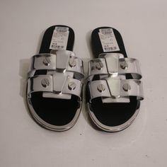 Nwt Womens Dkny Glynn Silver Chrome Leather Flat Sandals 6 * Retail: $110 Size: 6 Color: Silver Slip-On Flat Stud Detail Material: Leather Measurements (Flat): Length Heel- Toe: 9.6" Width: 3.6" New With Tags. (Bag/Z) Sondr- 4** Trendy Silver Sandals With Buckle Closure, Modern Silver Sandals With Buckle Closure, Silver Open Toe Sandals With Silver Studs, Silver Studded Open Toe Sandals, Modern Silver Sandals For Night Out, Trendy Silver Flat Sandals, Designer Silver Sandals For Night Out, Chic Silver Flat Sandals, Dkny Shoes