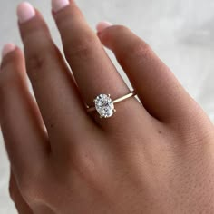 a woman's hand with a diamond ring on her left hand, showing the center stone