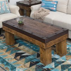 a living room with two couches, a coffee table and pillows on the floor