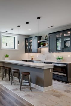 a kitchen with gray cabinets and white counter tops