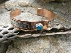 This is a beautiful Handcrafted Native American Made Copper With Sterling Silver Overlay Cuff Bracelet. The cuff is entirely Handcrafted which makes it a ONE OF A KIND. You get the EXACT bracelet cuff shown. This also has a Turquoise cabochon set in Sterling Silver to add a little bit more beauty to this design. This cuff is meticulously handcrafted by LC Littl a Native American Navajo silversmith, and the quality and attention to detail is truly exceptional. Get all the befits of wearing a copper bracelet, but also enjoying wearing a unique work of art! The Silversmith workmanship makes this bracelet a beautiful high quality handmade masterpiece. This is a nice size and will fit most average size wrist perfect for layering or wear it alone. The Opening is about 1.5 inches and can be adjus Southwestern Turquoise Cuff Bracelet As Gift, Southwestern Style Turquoise Cuff Bracelet As Gift, Turquoise Southwestern Cuff Bracelet As Gift, Southwestern Style Turquoise Cuff Bracelet For Gifts, Handmade Western Style Cuff Bracelet, Handmade Western Cuff Bracelet As Gift, Western Style Bracelet Jewelry Gift, Western Style Blue Cuff Bracelet Gift, Western Style Bangle Jewelry As Gift