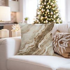 a living room with a christmas tree in the background and pillows on the couches