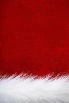 a red background with white fur and a santa claus hat on the bottom right corner