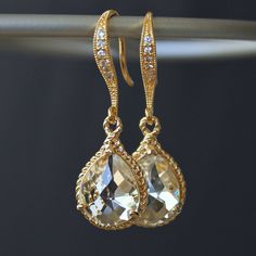 These beauties are standouts! Perfect for that special occasion! Elegant jeweled, french earrings carry stunning, teardrop crystals with a gold rope trim. The crystal detail on these earrings gives them such a classy and sophisticated feel. The last two pictures are for size reference. Details: * Gold-plated French Earrings * Faceted Crystal- 19 x 12mm(3/4x1/2") including rope trim * Length- 32mm(1 1/4") * Tarnish Resistant * Nickel and Lead-free These earrings come in an organza bag and gift box. Glamorous Gold Teardrop Earrings For Formal Events, Elegant Gold Teardrop Crystal Earrings, Elegant Gold Teardrop Earrings With Diamond Accents, Gold Teardrop Earrings With Diamond Accents For Wedding, Glamorous Gold Teardrop Dangle Earrings, Gold Pear-shaped Earrings With Diamond Accents, Gold Crystal Teardrop Earrings, Classic Gold Teardrop Earrings With Diamond Accents, Glamorous Gold Drop Bridal Earrings