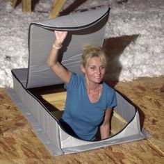 a woman sitting in a small boat made out of plywood planks and cardboard