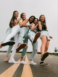 a group of young women standing next to each other on top of an airport runway