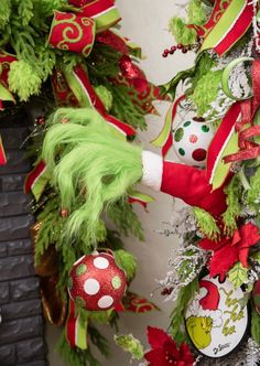 the grin's christmas wreath is hanging on the wall next to a fire place