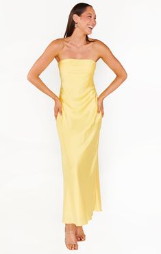 a woman in a yellow dress is smiling