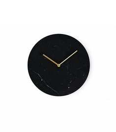 a black marble clock with gold hands on a white background, showing the time in roman numerals