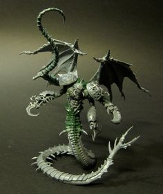 a green and white dragon figurine on a black surface