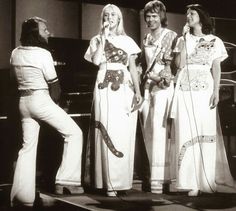 the four women are singing on stage together