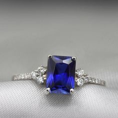 An impressive radiant cut Sapphire brings rich color to this ring, contrasted by brilliant diamond side stones set in a shimmering 10,14 or 18 Karat gold setting.- Made to Order, Perfectly finished, Fast shipping fully insured and trackable online.- Gemstone info: Sapphire corundum 8x6 mm, Excellent cut, 1.54 ct- Diamond info: 16 x Diamonds ranging from 1-1.75mm, VS-E, 0.15 ctw- Arrives gift ready with a certificate of authenticity Rectangular Lab-created Sapphire Ring For Anniversary, Anniversary Rectangular Lab-created Sapphire Ring, Radiant Cut Sapphire Ring With Accent Stones, Fine Jewelry Sapphire Square Cut Diamond Ring, Fine Jewelry Sapphire Diamond Ring With Square Cut, Luxury Radiant Cut Sapphire Rings With Diamond Accents, Luxury Square Cut Brilliant Sapphire Ring, Luxury Square-cut Brilliant Sapphire Ring, Luxury Square-cut Sapphire Ring With Brilliant Cut