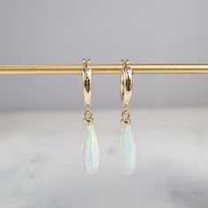 This beautiful pair of handmade earrings feature 2 White Opal gemstones. The earrings are handmade using nickel-free Sterling Silver. These earrings are simple and dainty, perfect for everyday wear. Makes a great gift to add to any gemstone lover's collection. Perfect to gift for Christmas, Valentine's Day, Mother's Day, and more! Gemstone: White Opal, Simulated Gemstone Size: 16.0 X 6.0 mm Metal: 14k Gold-Filled or Sterling Silver (Hypoallergenic) Shape: Elongated Teardrop, Half-Drill Earring B Dainty Teardrop Huggie Earrings With Ear Wire, Small Hoop Earrings With Lever Back For Gift, Hypoallergenic Small Hoop Earrings In 14k Gold Filled, Adjustable Hypoallergenic Teardrop Huggie Earrings, Handmade 14k Gold Filled Drop Huggie Earrings, Single Long Drop Hoop Earring As A Gift, Handmade 14k Gold Filled Dangle Huggie Earrings, Long Drop Hoop Earrings Gift, Dainty Dangle Hoop Earrings As Gift For Her