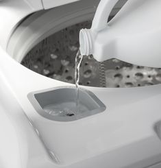 a close up of a washing machine with water pouring out of the front and side