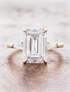 an emerald cut diamond ring with three baguets