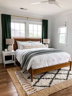 a bedroom with a large bed and green curtains